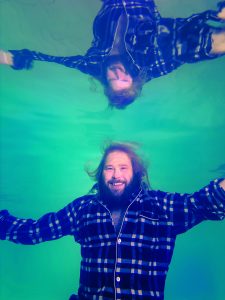 James Rowland underwater with his reflection as a promo for his show, Piece of Work.