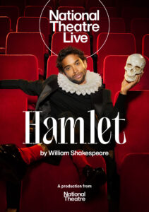 The National Theatre Live poster for 'Hamlet'. By William Shakespeare. Starring Hiran Abeysekera, who is wearing a collar ruff and a modern black suit, sat in red, plush theatre seats, looking directly at the camera and holding a skull.